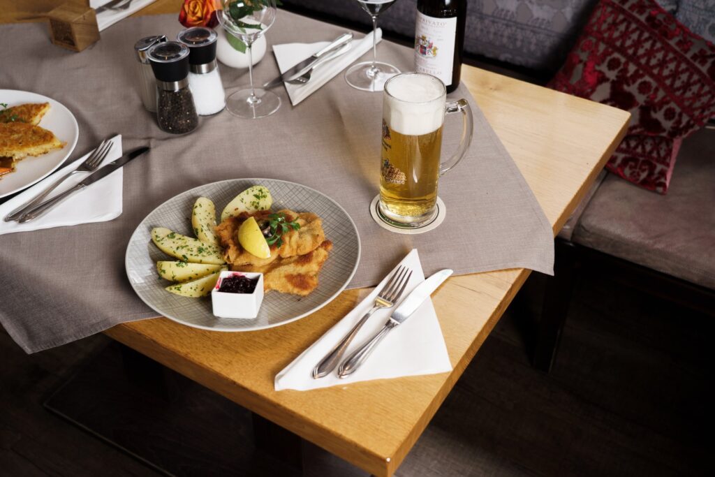 Gedeckter Tisch mit Kalbsschnitzel und Bier im Dechbettener Hof